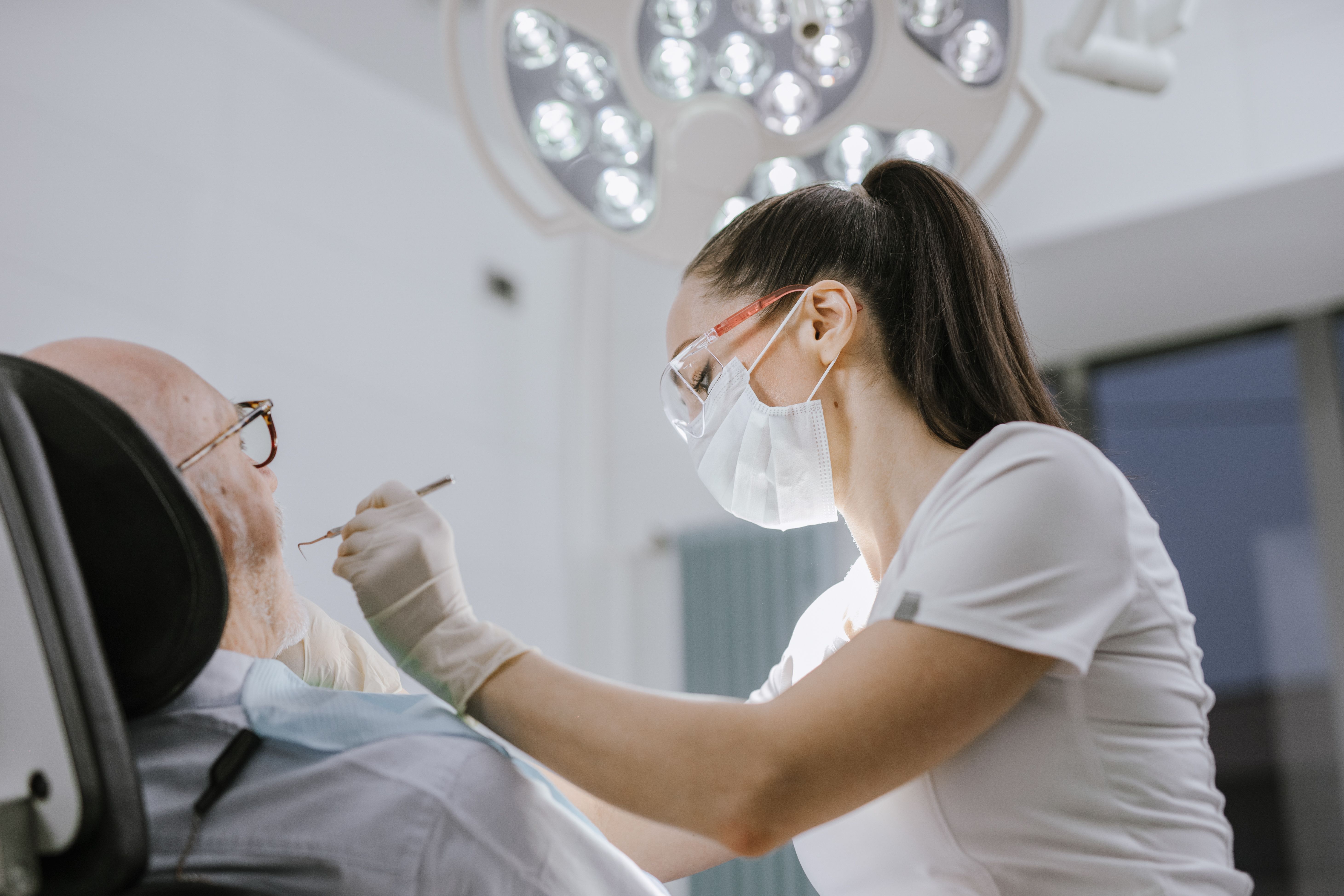 Dentist examining a patient under the operatory light
